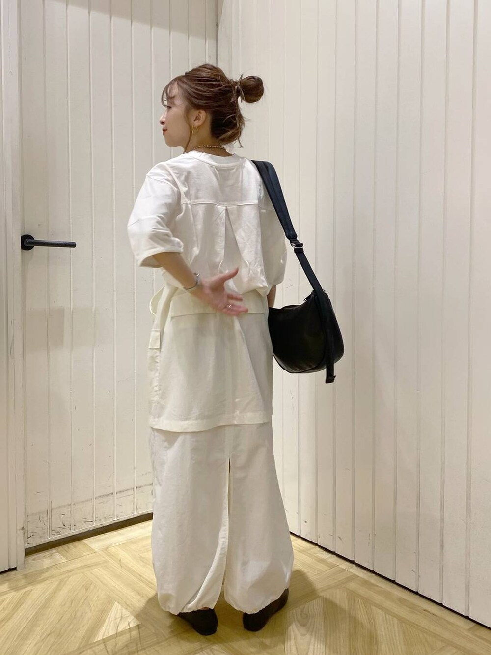 ブラック系のパンプス、ブラック系のショルダーバッグ、ホワイト系のTシャツ/カットソーを着用したレディースの夏コーディネートの2枚目の写真