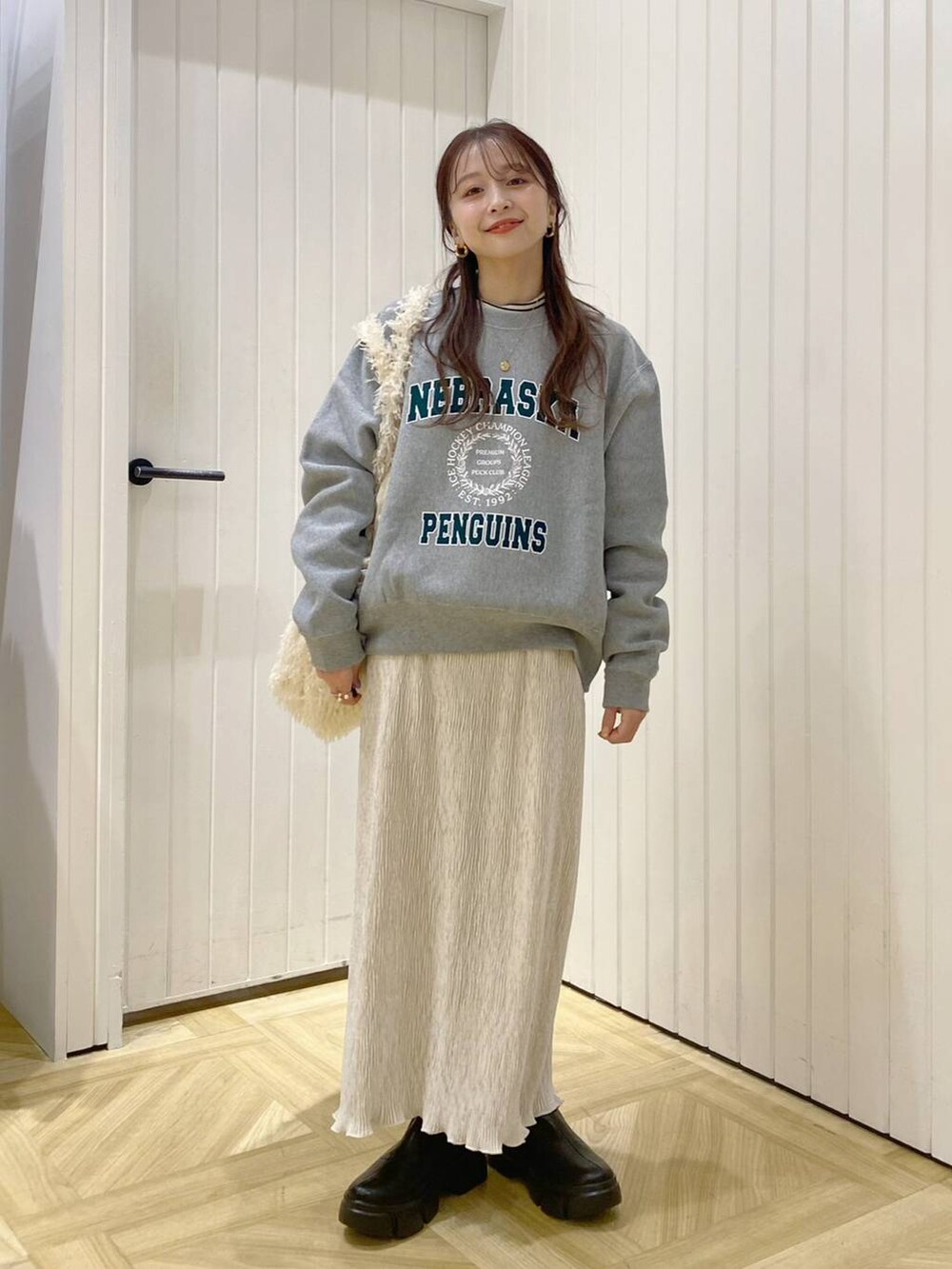 ブラック系のブーツ、グレー系のスウェット、ホワイト系のスカートを着用したレディースの冬コーディネートの4枚目の写真