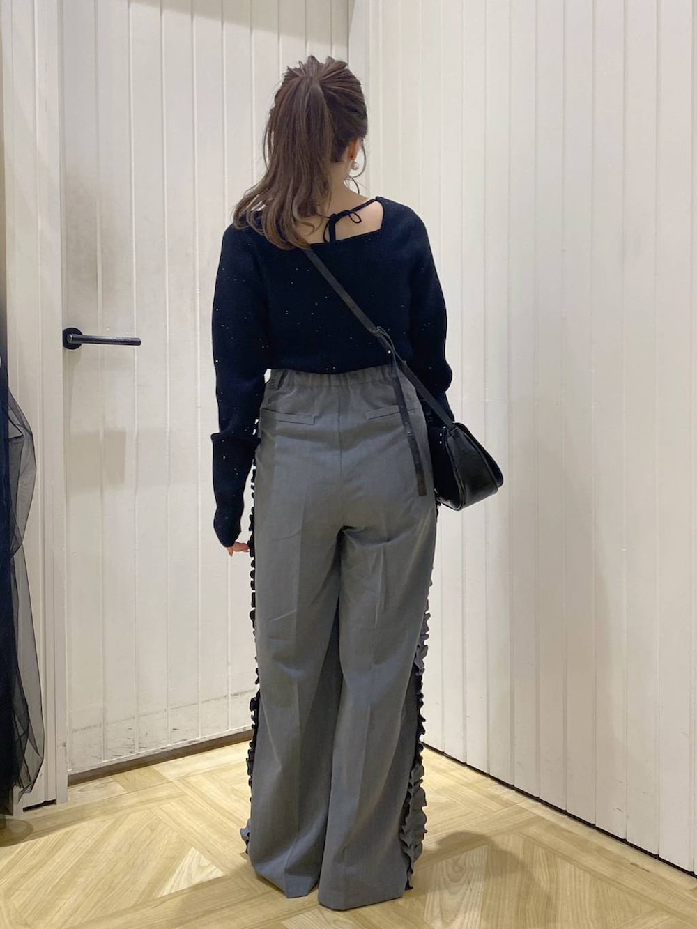 ブラック系のショルダーバッグ、ホワイト系のブーツ、グレー系のその他パンツを着用したレディースの秋コーディネートの3枚目の写真