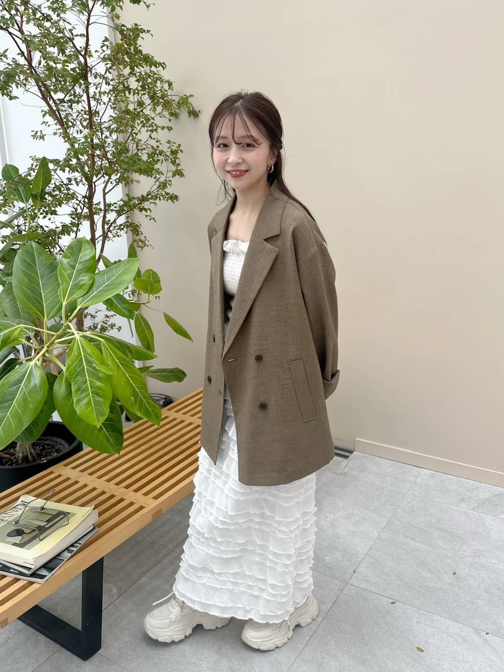 ホワイト系のスカート、ホワイト系のスニーカー、ブラウン系のテーラードジャケットを着用したレディースの冬コーディネートの4枚目の写真
