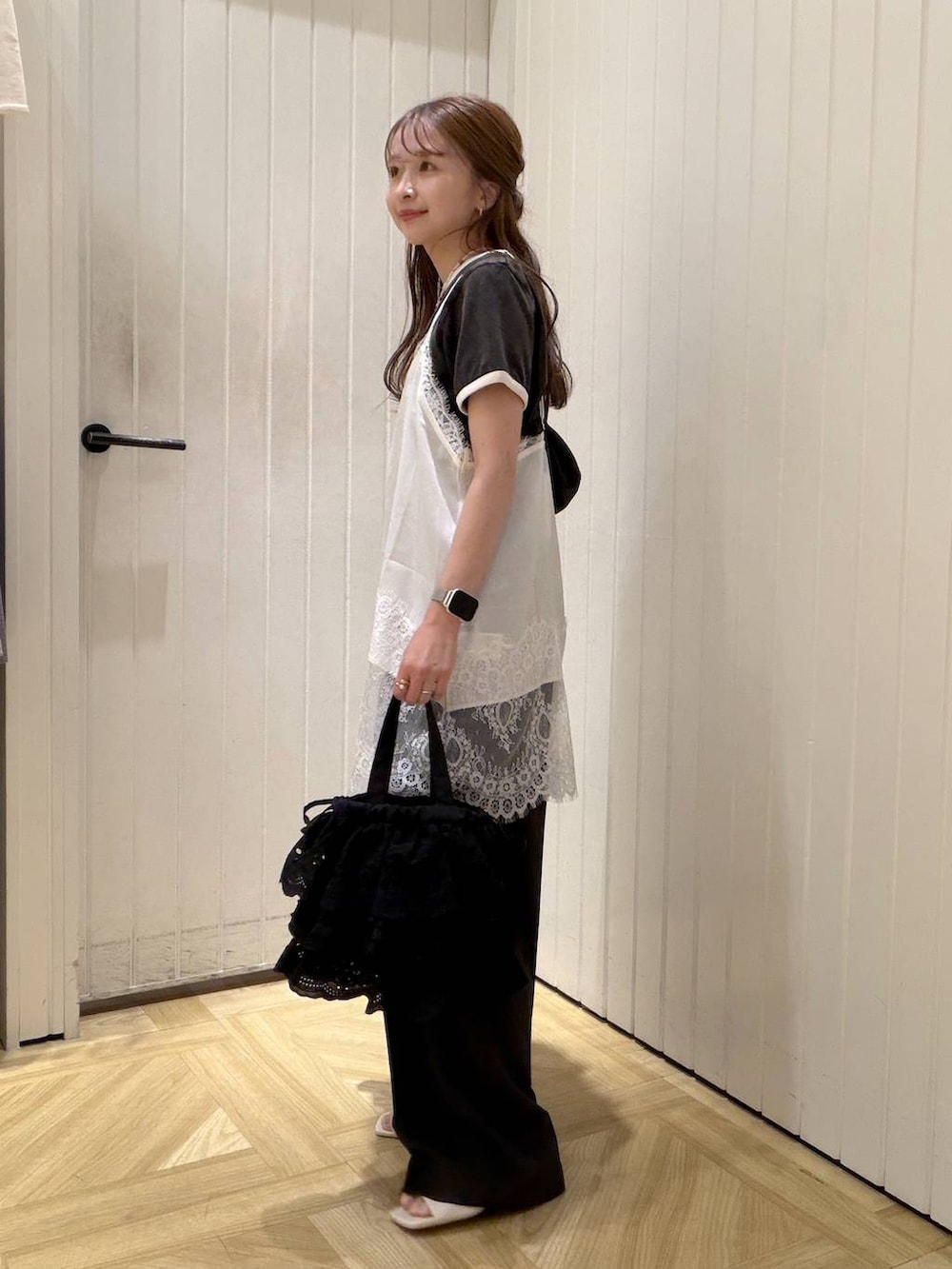 グレー系のスラックス、グレー系のTシャツ/カットソー、ブラック系のハンドバッグを着用したレディースの春コーディネートの2枚目の写真