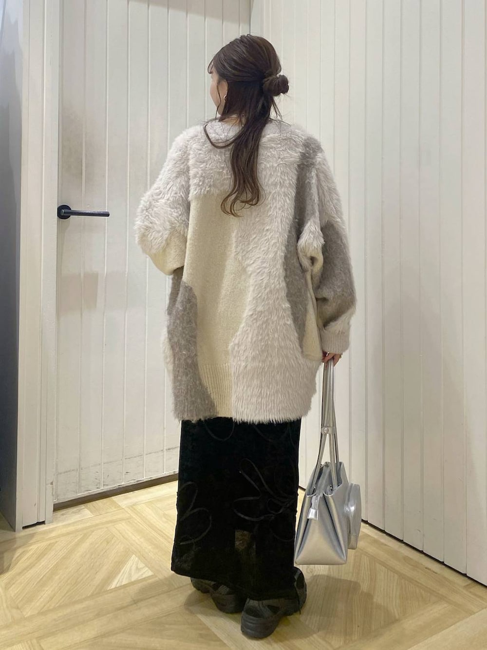 ブラック系のその他シューズ、シルバー系のショルダーバッグ、ホワイト系のカーディガン/ボレロを着用したレディースの秋コーディネートの2枚目の写真