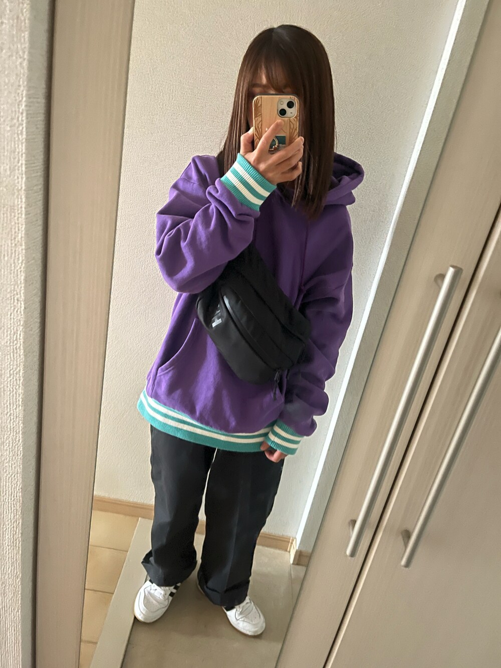 ブラック系のボディバッグ/ウエストポーチ、ブラック系のチノパンツ、ホワイト系のスニーカーを着用したレディースの秋コーディネートの2枚目の写真