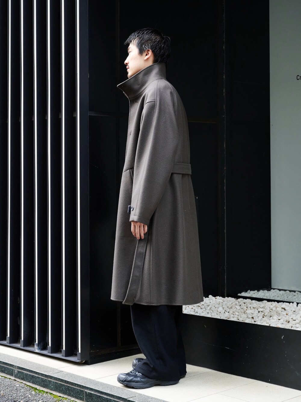 グレー系のチェスターコートを着用したメンズの秋コーディネートの3枚目の写真