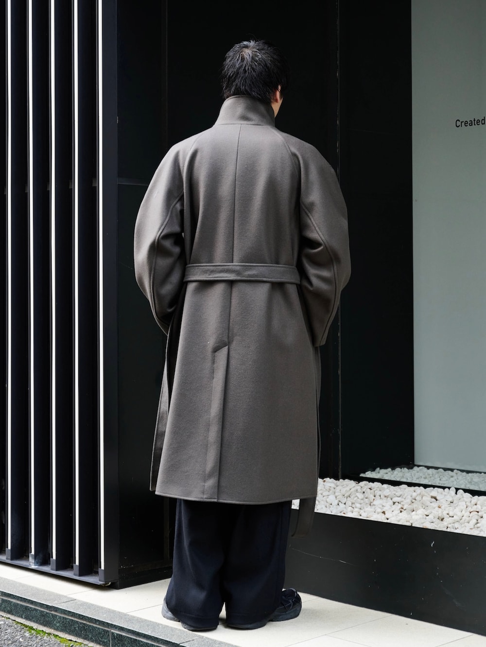 グレー系のチェスターコートを着用したメンズの秋コーディネートの4枚目の写真