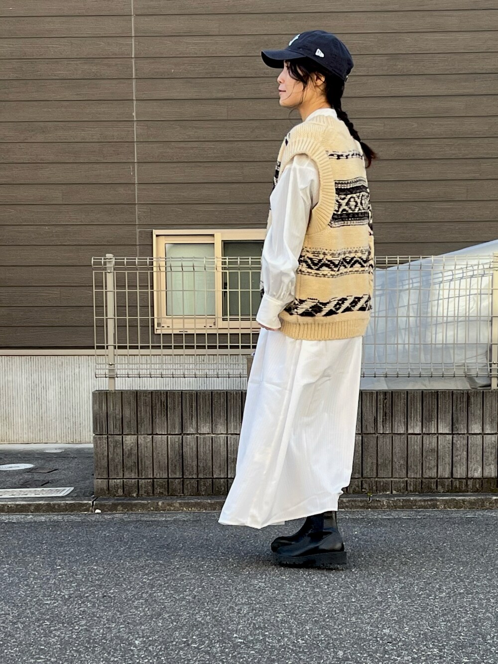 ホワイト系のニット/セーター、ホワイト系のシャツワンピース、ブルー系のキャップを着用したレディースの冬コーディネートの2枚目の写真