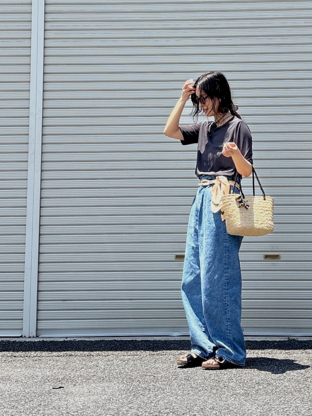 ホワイト系のチューブトップ、ブラック系のサンダル、ブルー系のデニムパンツを着用したレディースの夏コーディネートの3枚目の写真