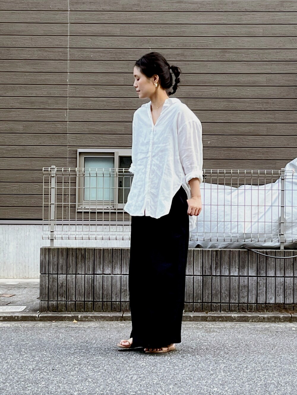 ブラック系のスカート、ホワイト系のシャツ/ブラウス、シルバー系のバングル/リストバンドを着用したレディースの夏コーディネートの2枚目の写真