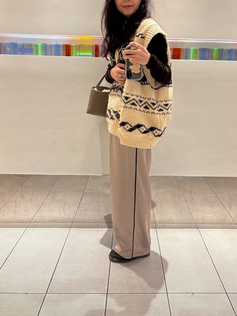 ベージュ系のスラックス、ブラウン系のTシャツ/カットソー、ホワイト系のニット/セーターを着用したレディースの秋コーディネートの2枚目の写真