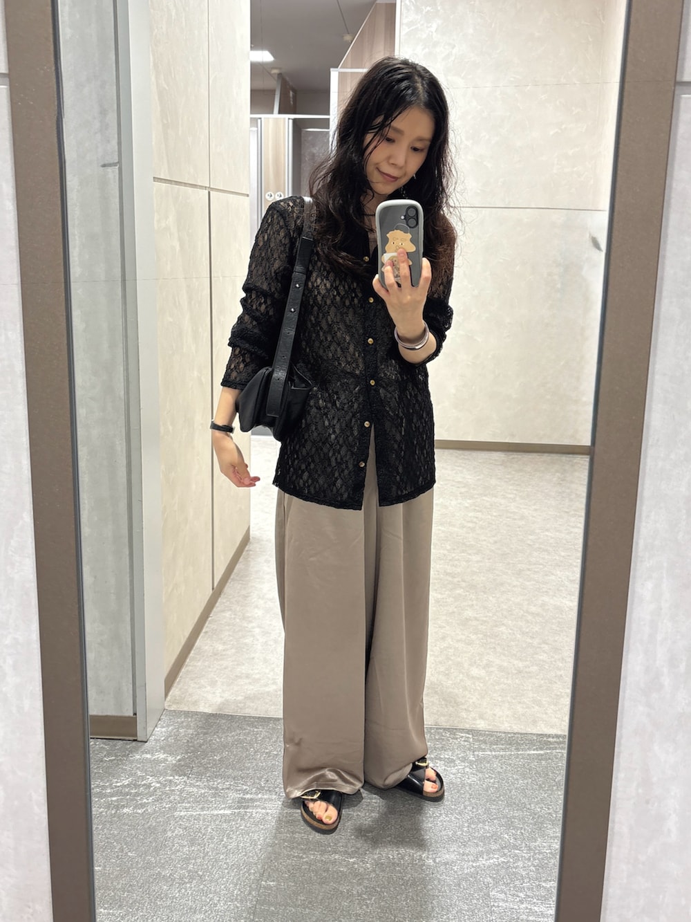 ベージュ系のスラックス、ブラック系のカーディガン/ボレロ、ブラック系のサンダルを着用したレディースの秋コーディネートの2枚目の写真