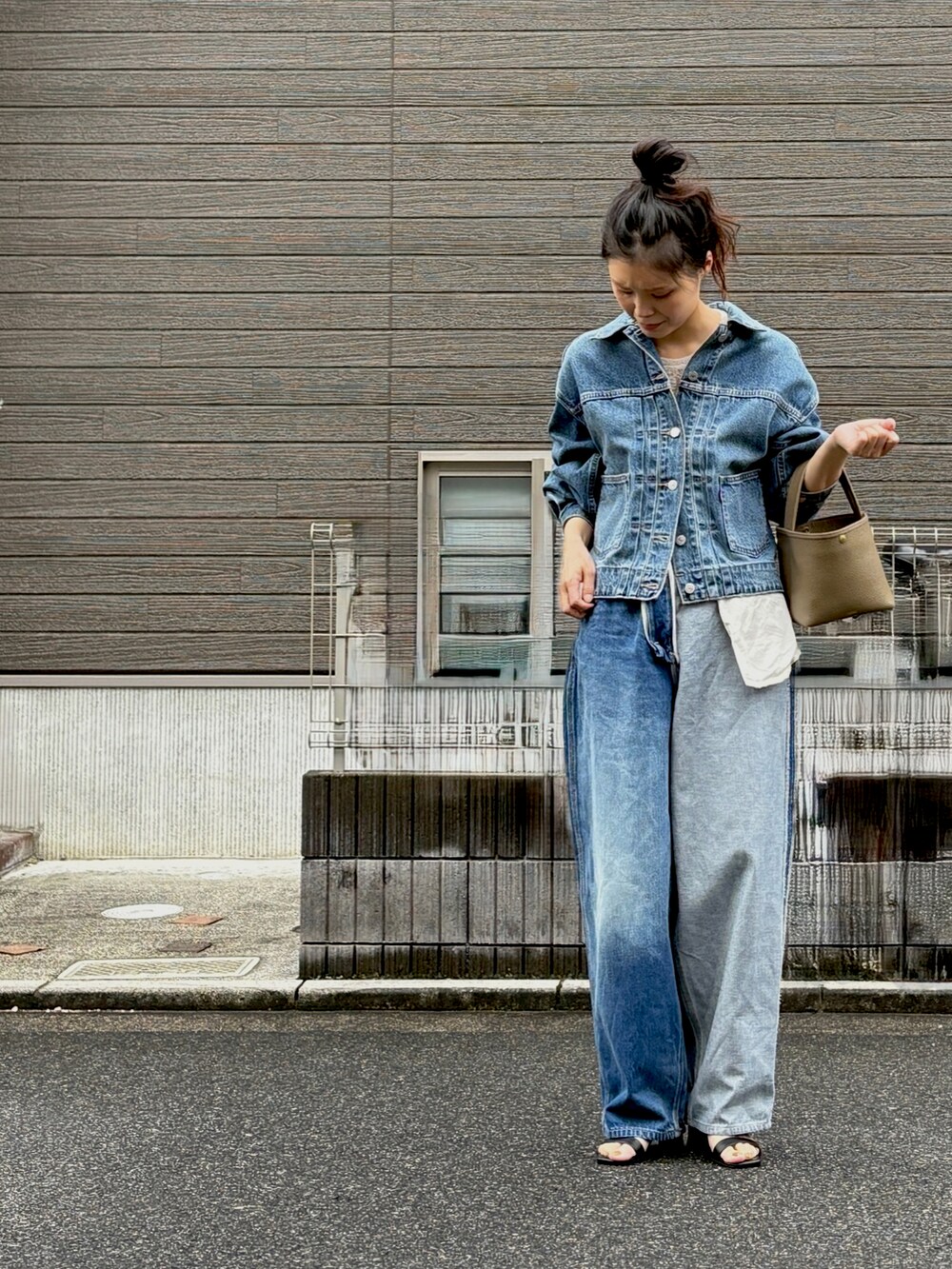 ブルー系のデニムパンツ、ブルー系のデニムジャケット、ブラック系のサンダルを着用したレディースの秋コーディネートの3枚目の写真