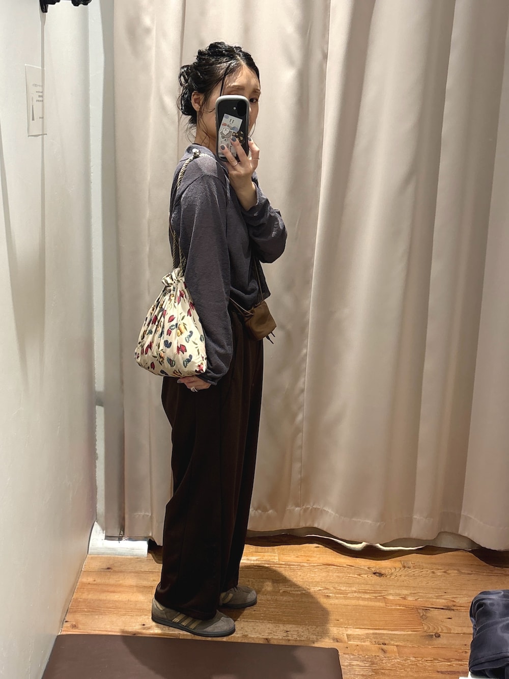 グレー系のニット/セーター、ブラウン系のショルダーバッグ、ブラウン系のスニーカーを着用したレディースの夏コーディネートの3枚目の写真