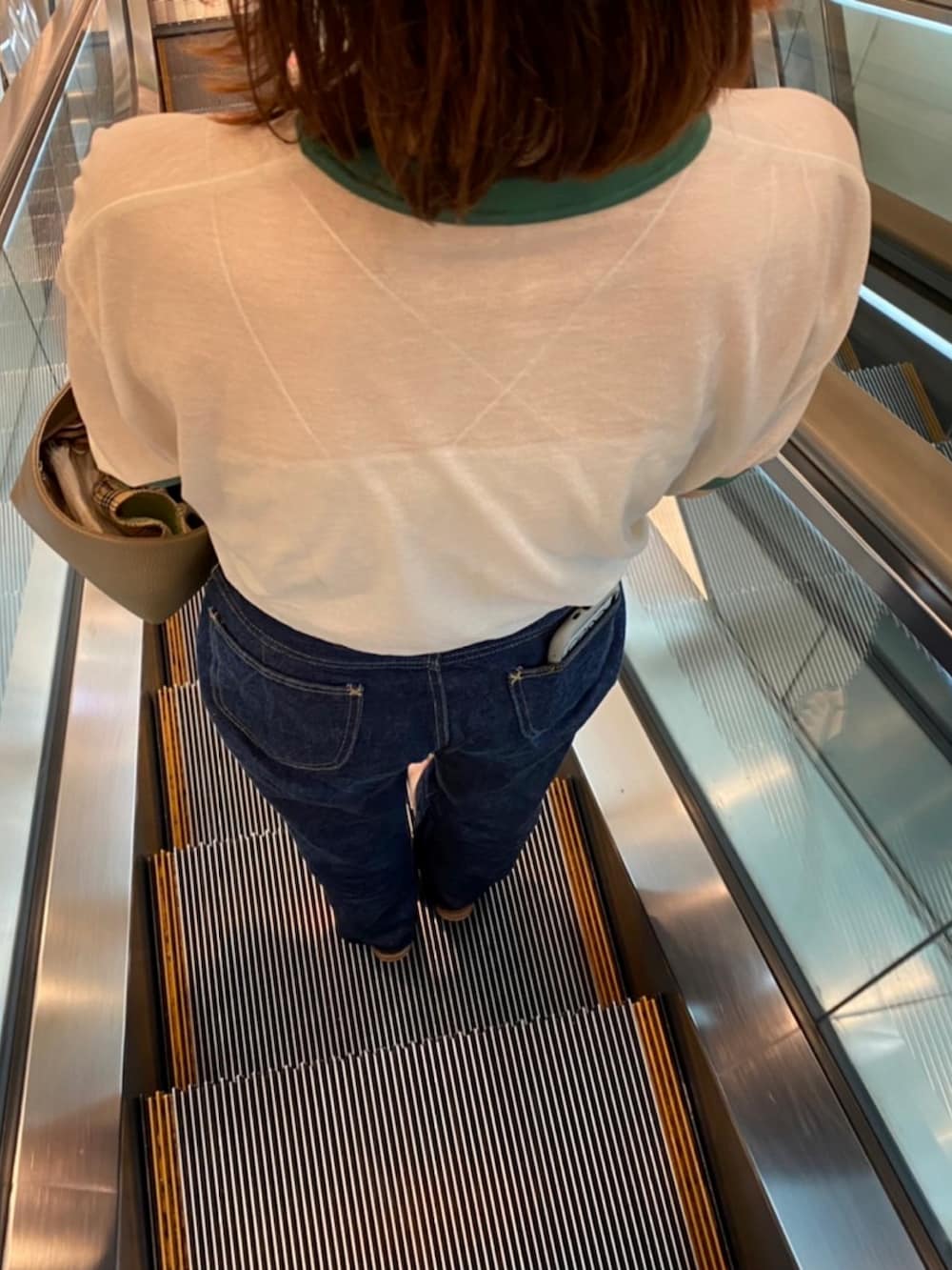 ベージュ系のTシャツ/カットソー、ブルー系のデニムパンツ、ベージュ系のキャミソールを着用したレディースの夏コーディネートの2枚目の写真