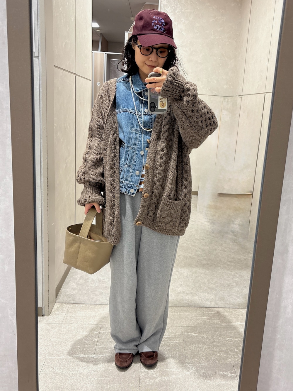 ブラウン系のTシャツ/カットソー、ブルー系のデニムジャケット、グレー系のスウェットパンツを着用したレディースの春コーディネートの2枚目の写真