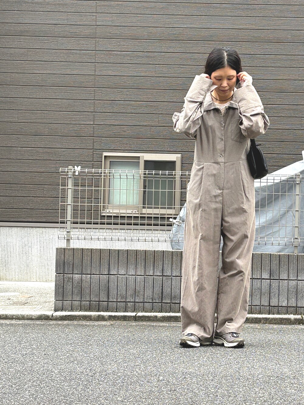 ホワイト系のTシャツ/カットソー、ブラウン系のつなぎ/オールインワン、グレー系のスニーカーを着用したレディースの秋コーディネートの2枚目の写真