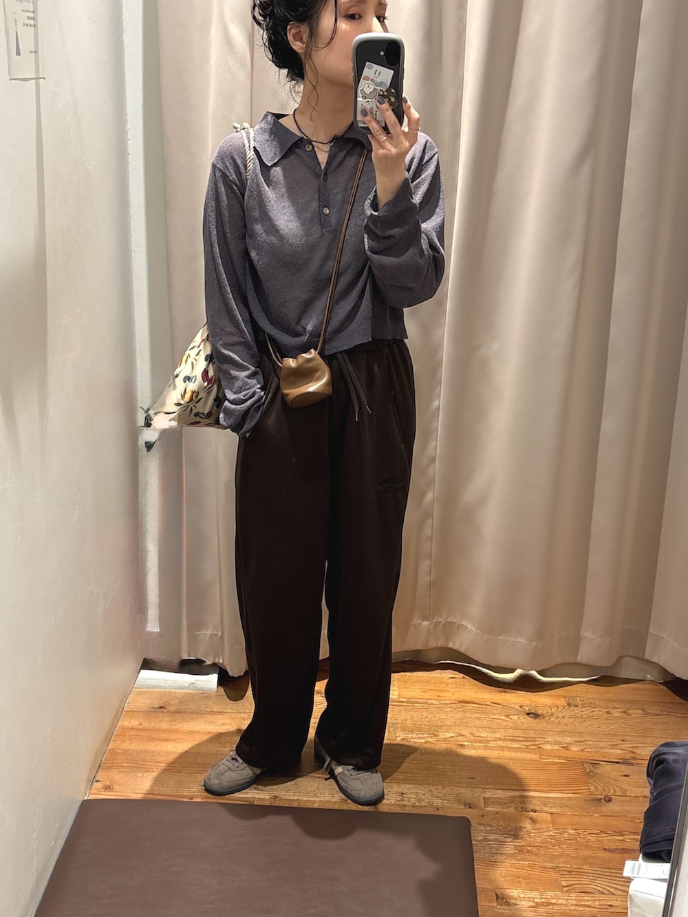 グレー系のニット/セーター、ブラウン系のショルダーバッグ、ブラウン系のスニーカーを着用したレディースの夏コーディネートの2枚目の写真