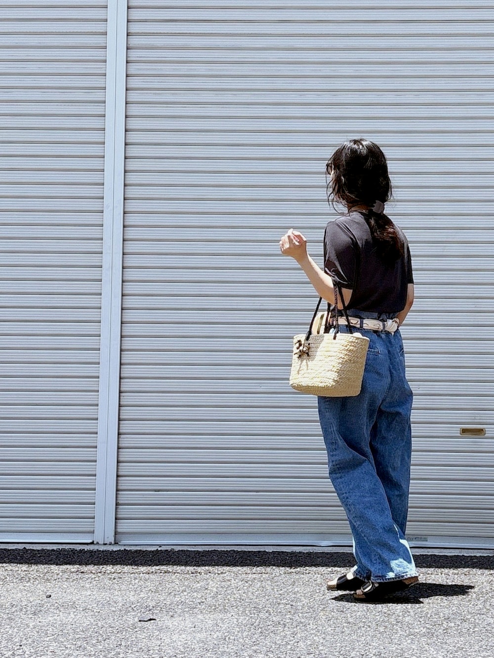 ホワイト系のチューブトップ、ブラック系のサンダル、ブルー系のデニムパンツを着用したレディースの夏コーディネートの2枚目の写真