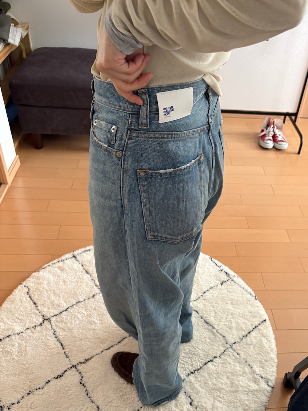 ブルー系のデニムパンツ、ホワイト系のカーディガン/ボレロ、ブラウン系のローファーを着用したレディースの春コーディネートの2枚目の写真