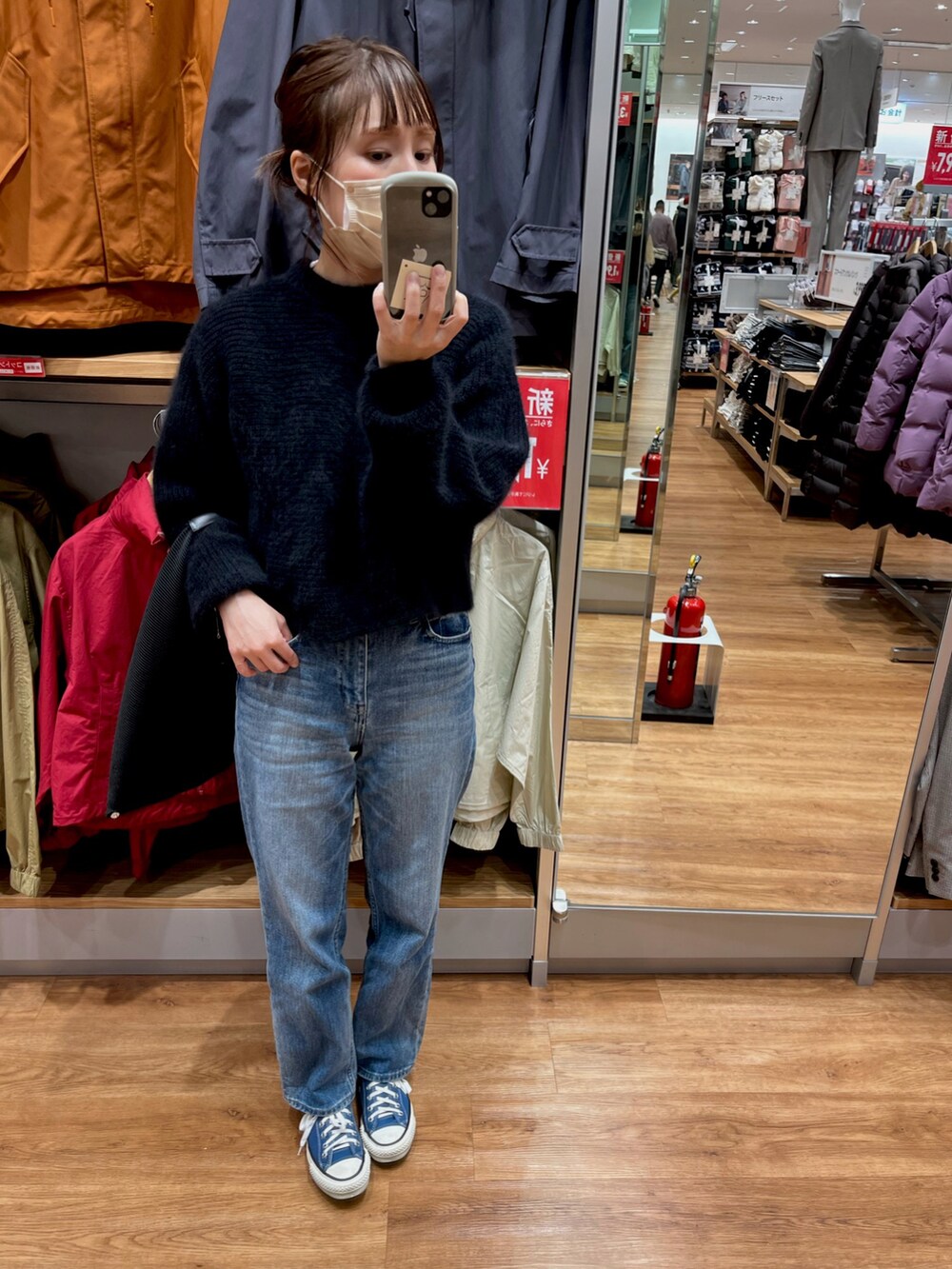 ブラック系のニット/セーター、ブルー系のデニムパンツ、ブラック系のショルダーバッグを着用したレディースの冬コーディネートの2枚目の写真