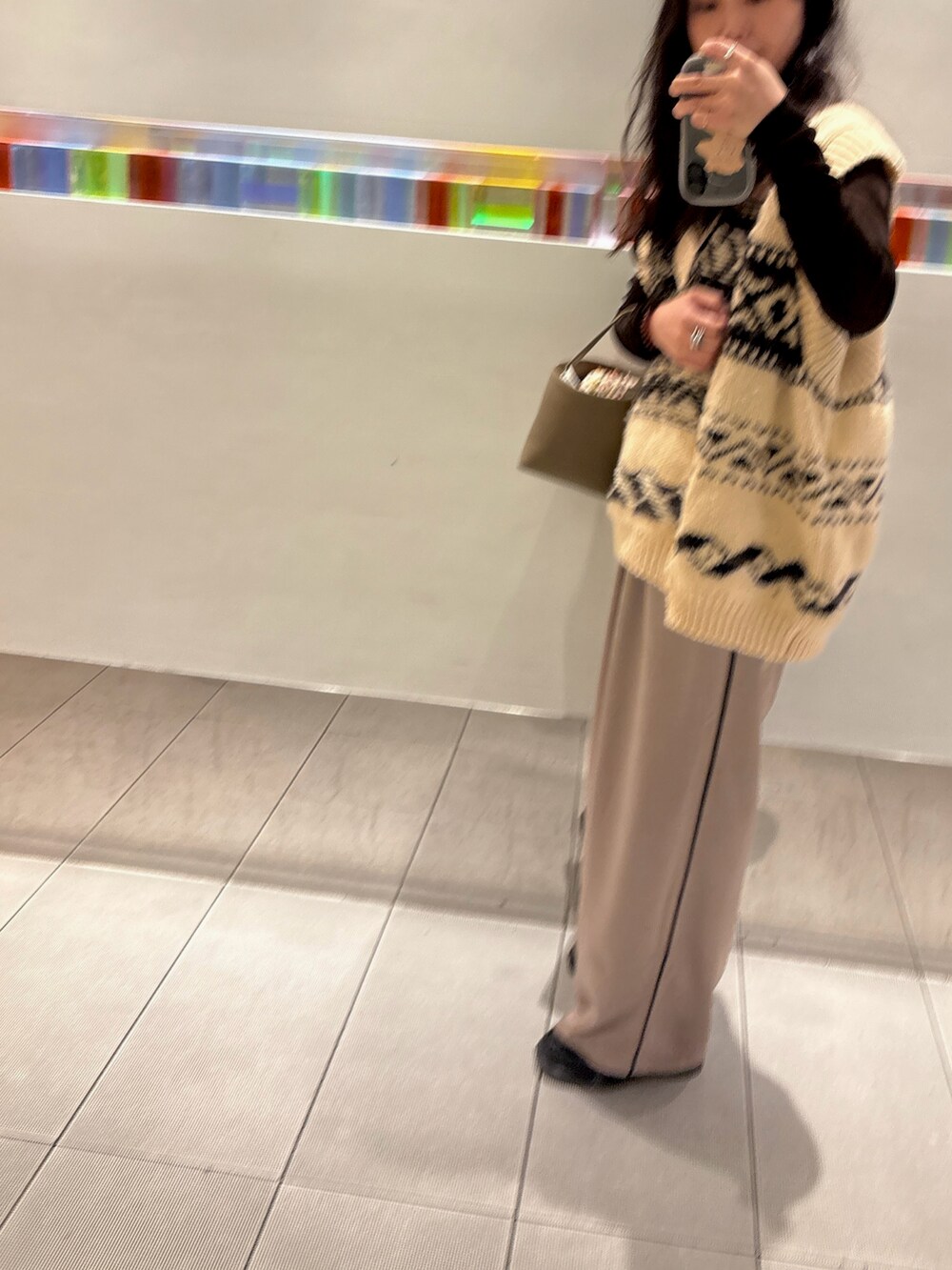 ベージュ系のスラックス、ブラウン系のTシャツ/カットソー、ホワイト系のニット/セーターを着用したレディースの秋コーディネートの3枚目の写真