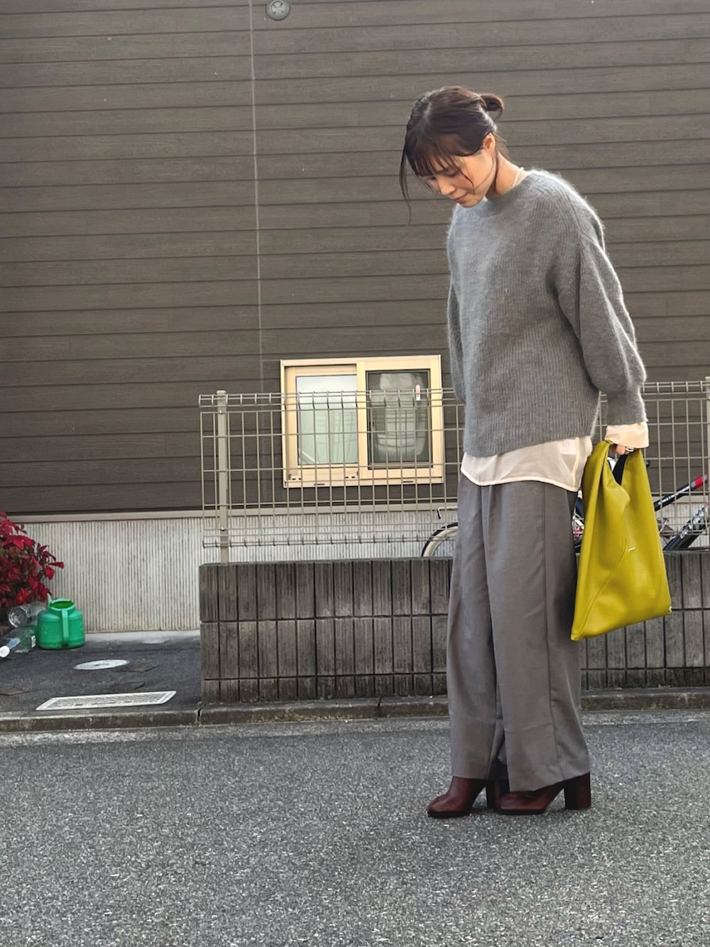 グレー系のニット/セーター、その他のハンドバッグ、ホワイト系のシャツ/ブラウスを着用したレディースの冬コーディネートの2枚目の写真