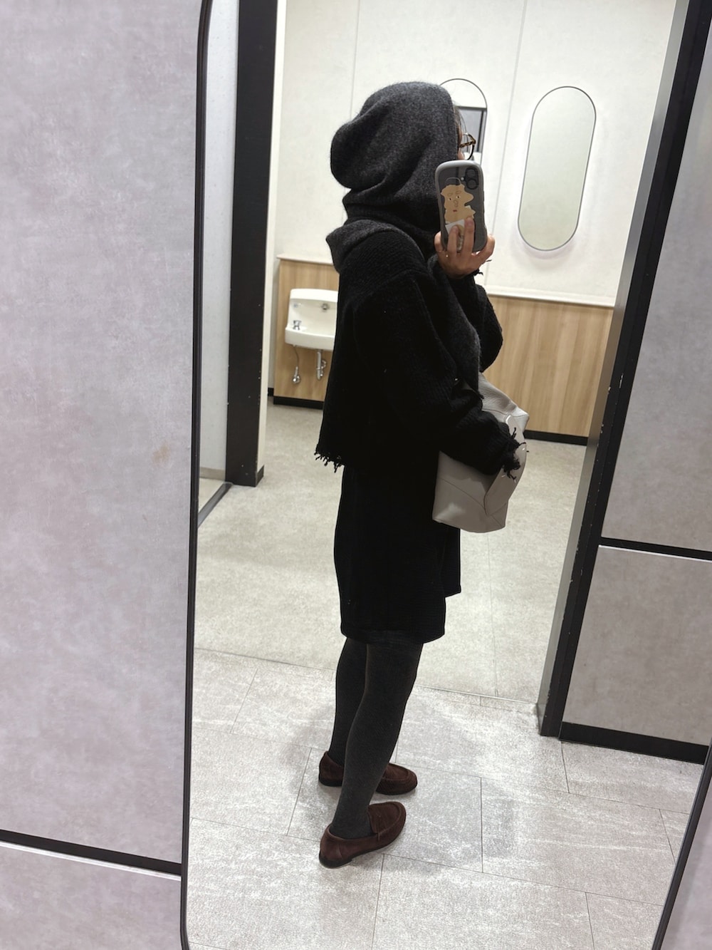 ブラック系のその他パンツ、ブラウン系のローファー、ベージュ系のショルダーバッグを着用したレディースの冬コーディネートの2枚目の写真