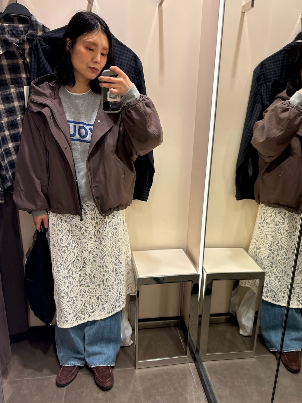 ブラウン系のマウンテンパーカー、ブルー系のデニムパンツ、ホワイト系のバンダナ/スカーフを着用したレディースの春コーディネートの2枚目の写真