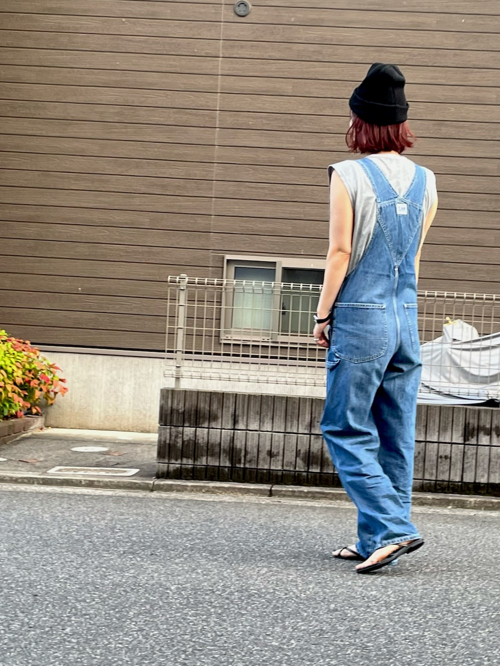 グレー系のTシャツ/カットソー、ブルー系のサロペット/オーバーオール、ブラック系のサンダルを着用したレディースの夏コーディネートの2枚目の写真