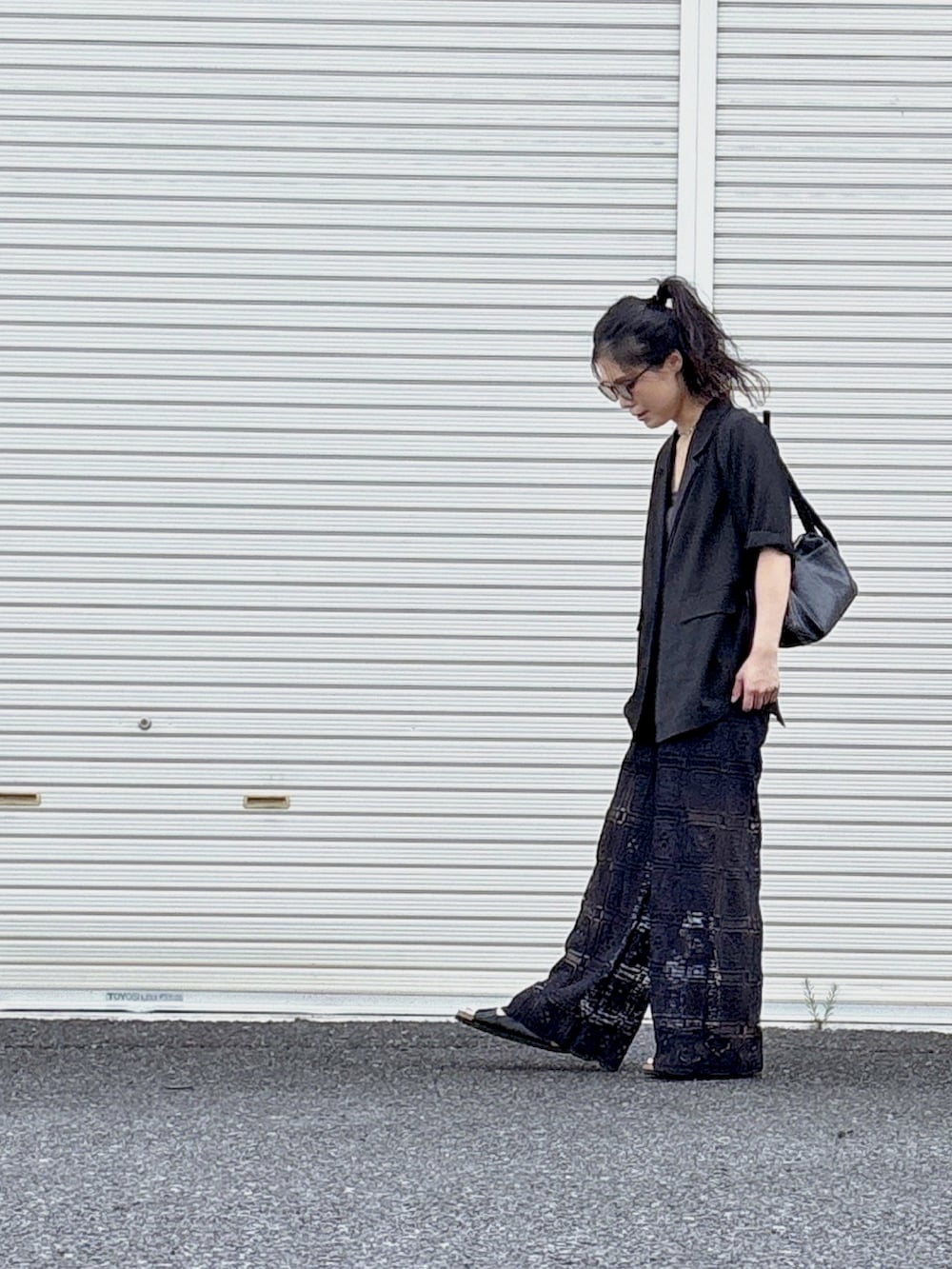 ブラック系のその他パンツ、ブラック系のショルダーバッグ、ブラック系のサンダルを着用したレディースの夏コーディネートの2枚目の写真