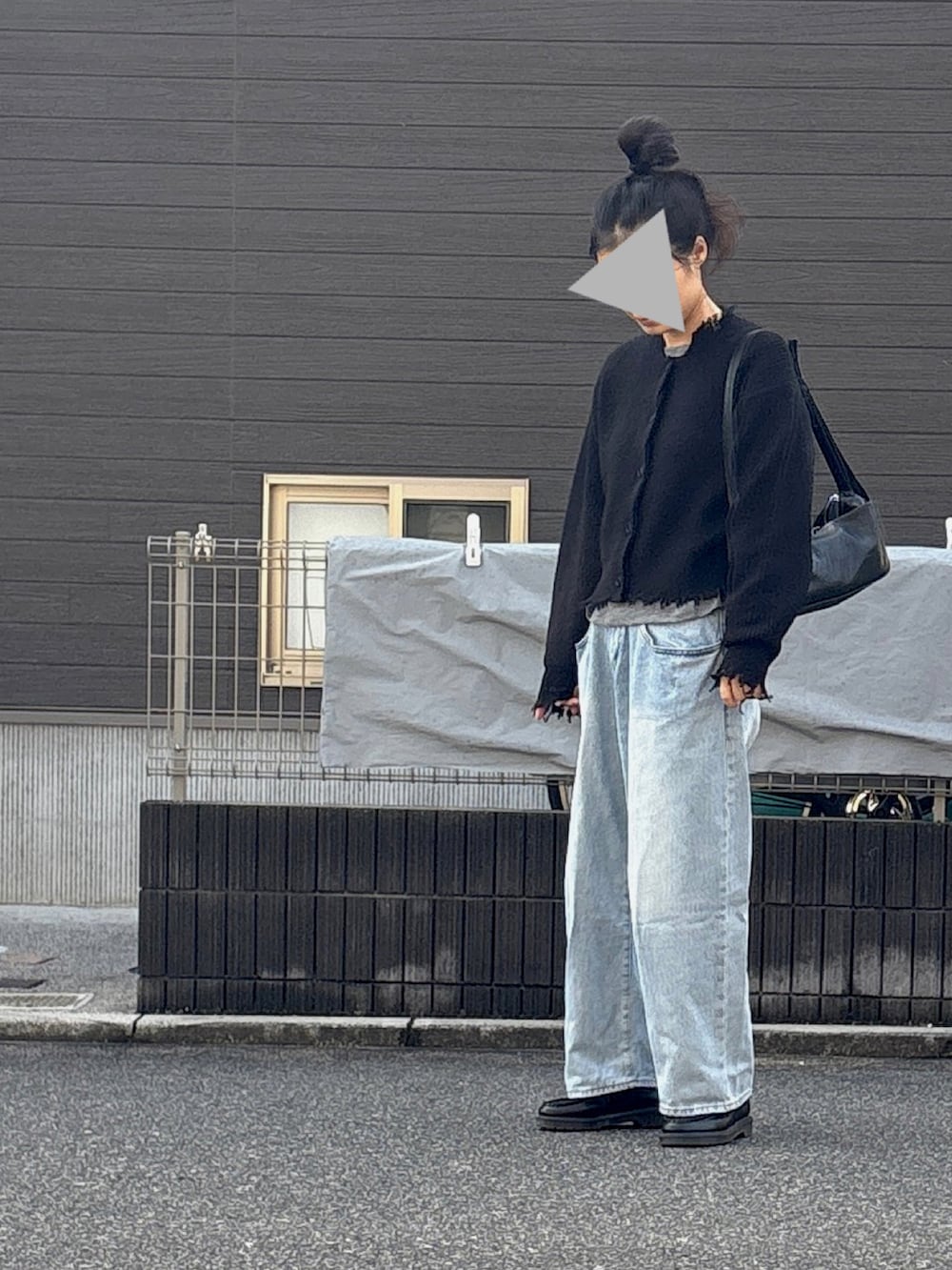 ブラック系のショルダーバッグ、ブルー系のデニムパンツを着用したレディースの秋コーディネートの3枚目の写真