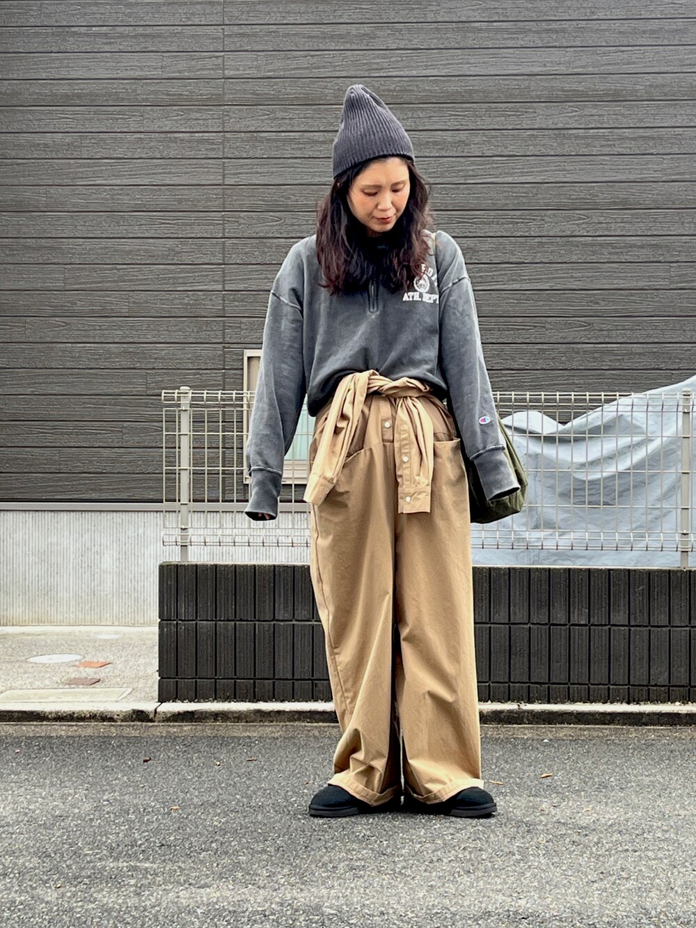 ブラック系のスウェット、ブラック系のブーツ、ベージュ系のつなぎ/オールインワンを着用したレディースの冬コーディネートの2枚目の写真