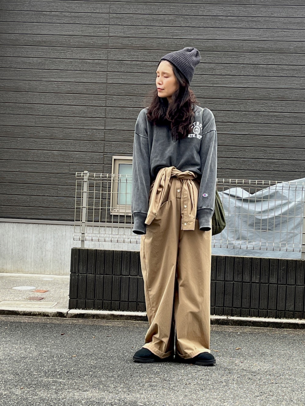 ブラック系のスウェット、ブラック系のブーツ、ベージュ系のつなぎ/オールインワンを着用したレディースの冬コーディネートの3枚目の写真