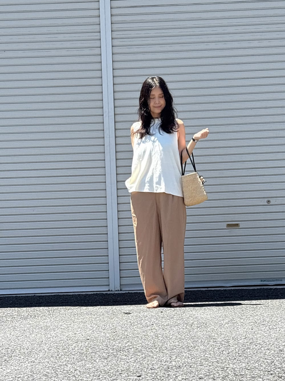 ブラウン系のサンダル、ホワイト系のニット/セーター、イエロー系のスラックスを着用したレディースの夏コーディネートの3枚目の写真