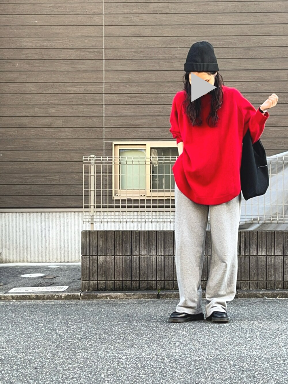 レッド系のニット/セーター、グレー系のスウェットパンツ、ブラック系のローファーを着用したレディースの秋コーディネートの2枚目の写真