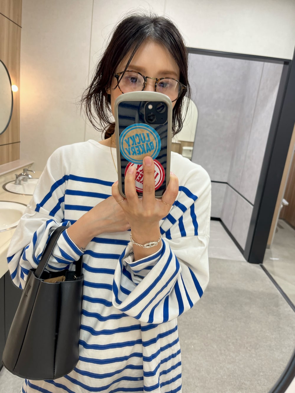 ブルー系のTシャツ/カットソー、ホワイト系のスウェットパンツ、ブラック系のショルダーバッグを着用したレディースの秋コーディネートの2枚目の写真