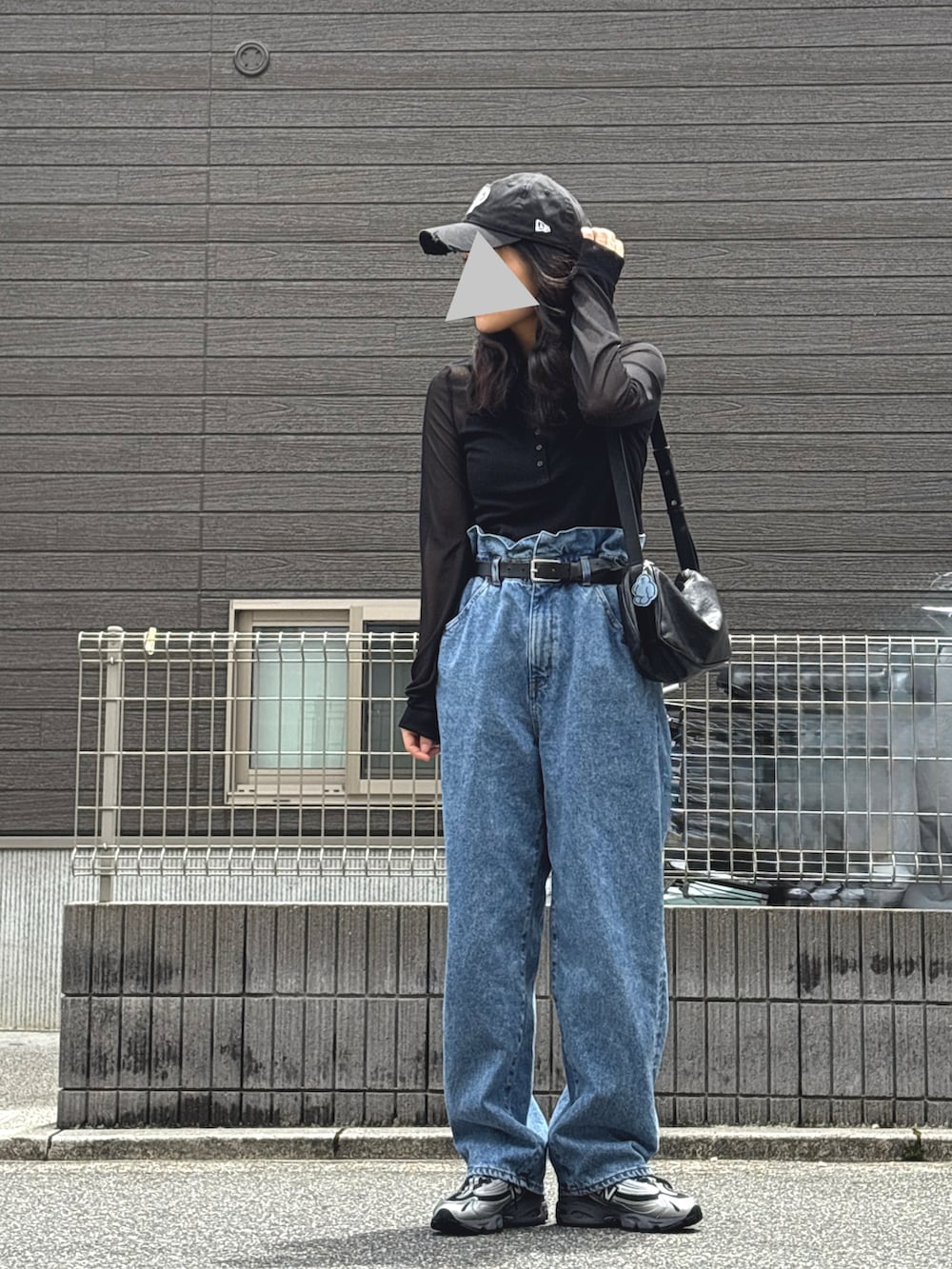 ブラック系のシャツ/ブラウス、グレー系のスニーカー、ブルー系のデニムパンツを着用したレディースの春コーディネートの2枚目の写真