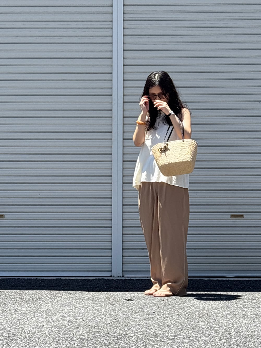 ブラウン系のサンダル、ホワイト系のニット/セーター、イエロー系のスラックスを着用したレディースの夏コーディネートの2枚目の写真