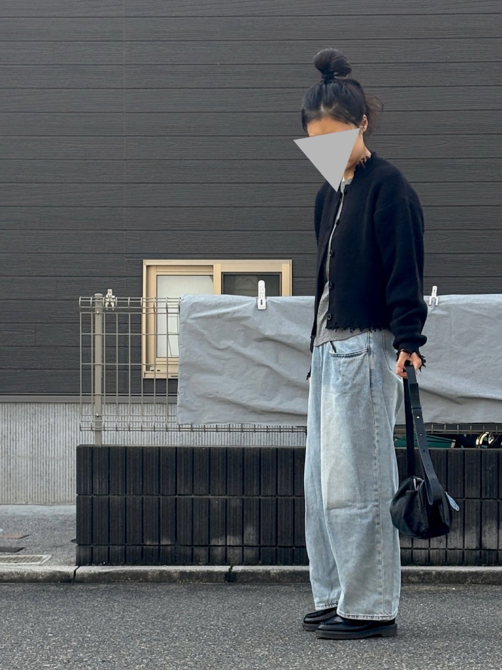 ブラック系のショルダーバッグ、ブルー系のデニムパンツを着用したレディースの秋コーディネートの2枚目の写真