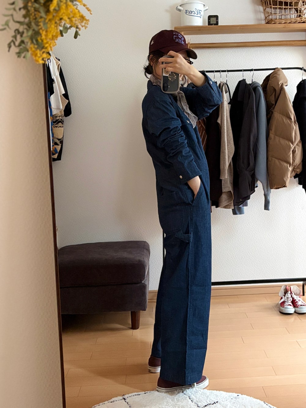 ブルー系のつなぎ/オールインワン、ブラウン系のスニーカー、レッド系のキャップを着用したレディースの春コーディネートの2枚目の写真