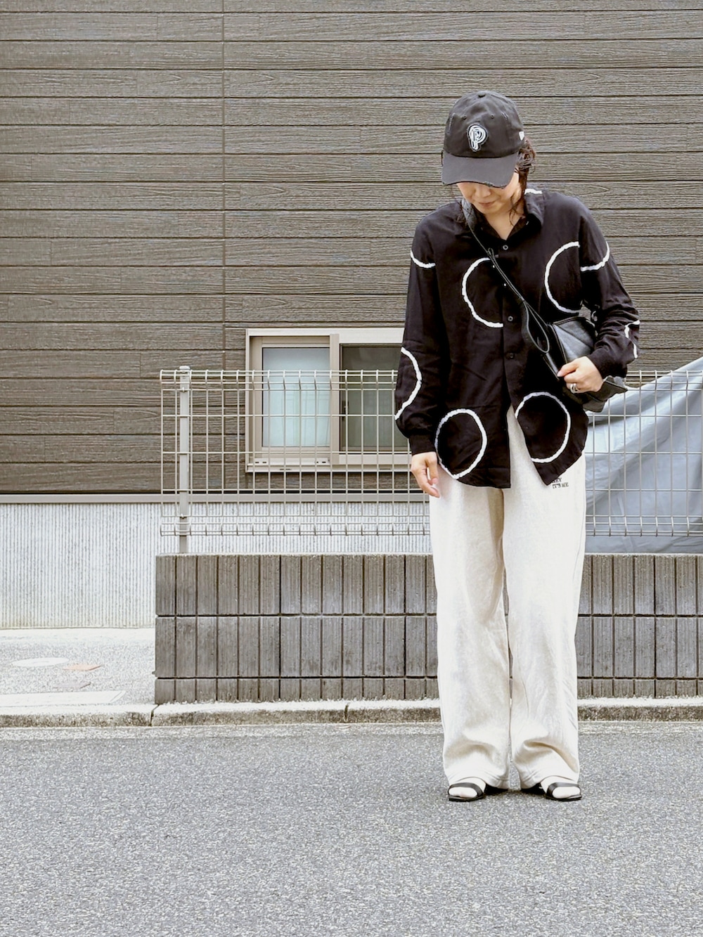 ホワイト系のその他パンツ、ブラック系のショルダーバッグ、ブラック系のキャップを着用したレディースの春コーディネートの2枚目の写真