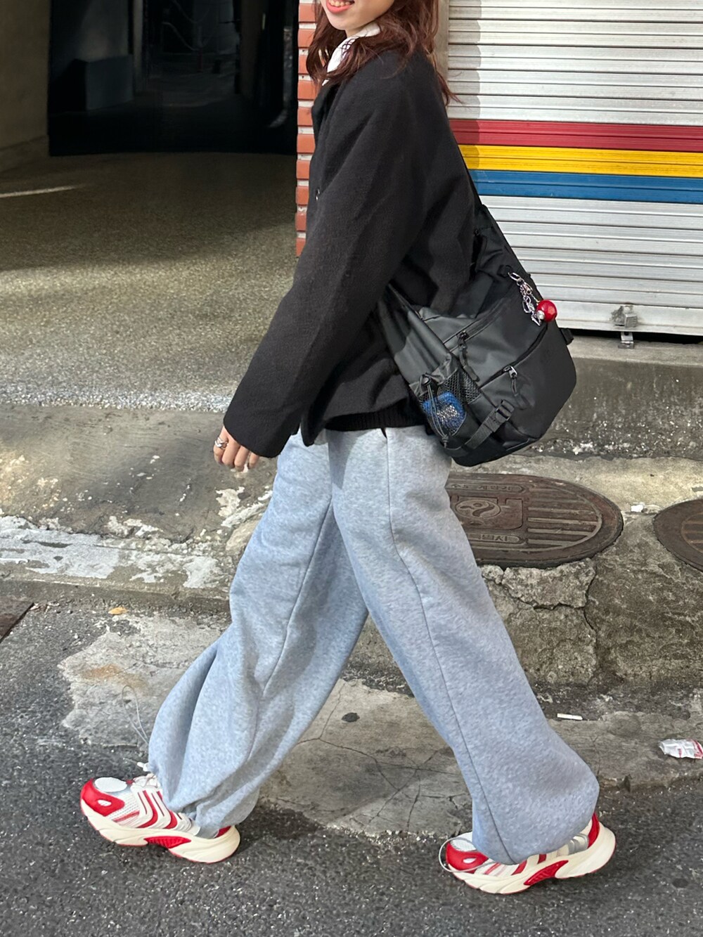 ブラック系のダウンジャケット/コート、グレー系のスウェットパンツ、レッド系のスニーカーを着用したレディースの冬コーディネートの2枚目の写真