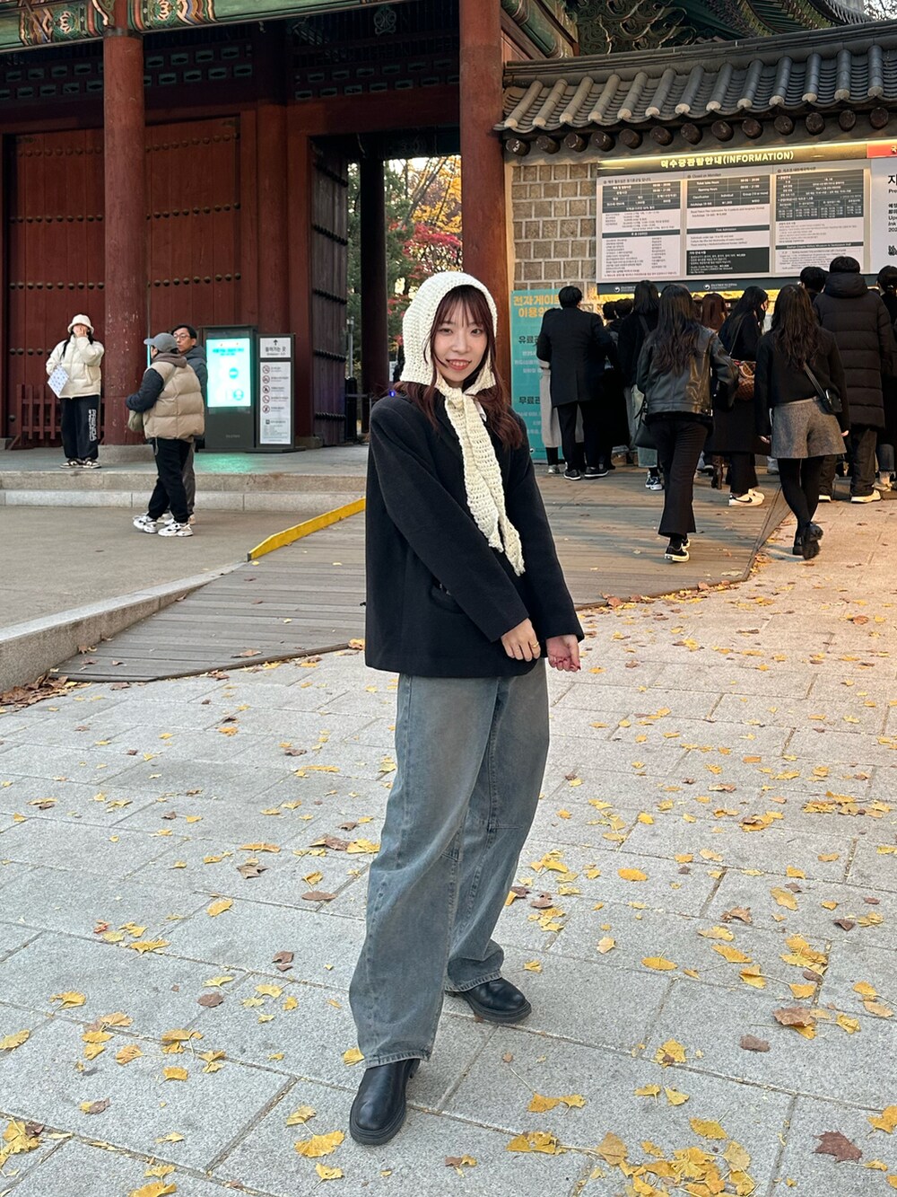 ブルー系のデニムパンツ、ブラック系のダウンジャケット/コート、ブラック系のブーツを着用したレディースの冬コーディネートの2枚目の写真