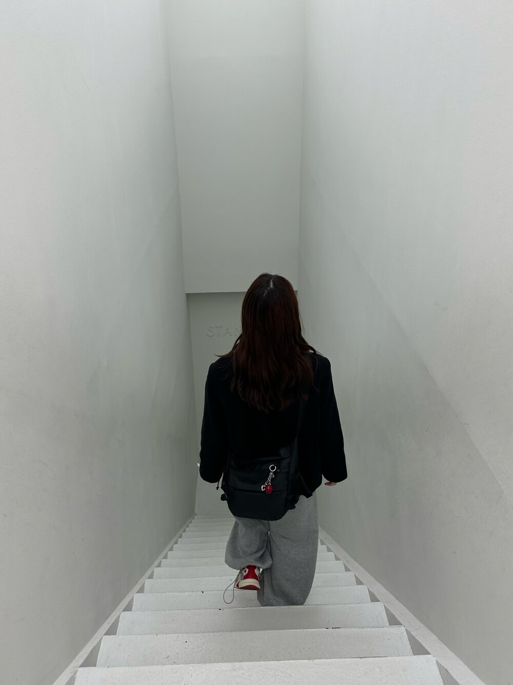 ブラック系のダウンジャケット/コート、グレー系のスウェットパンツ、レッド系のスニーカーを着用したレディースの冬コーディネートの4枚目の写真