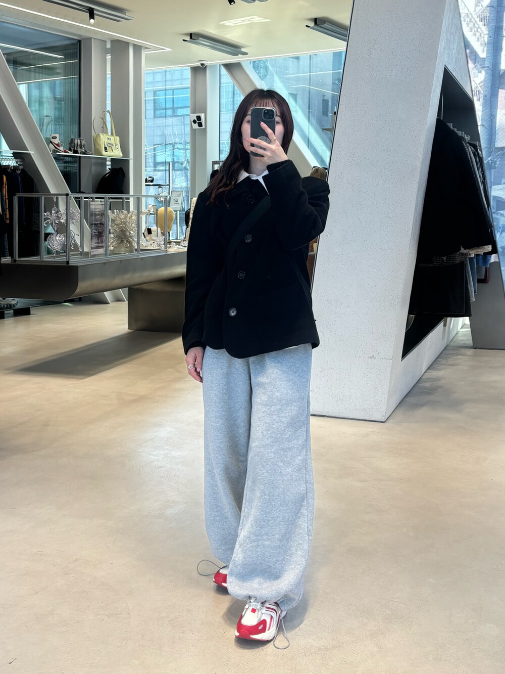 ブラック系のダウンジャケット/コート、グレー系のスウェットパンツ、レッド系のスニーカーを着用したレディースの冬コーディネートの3枚目の写真