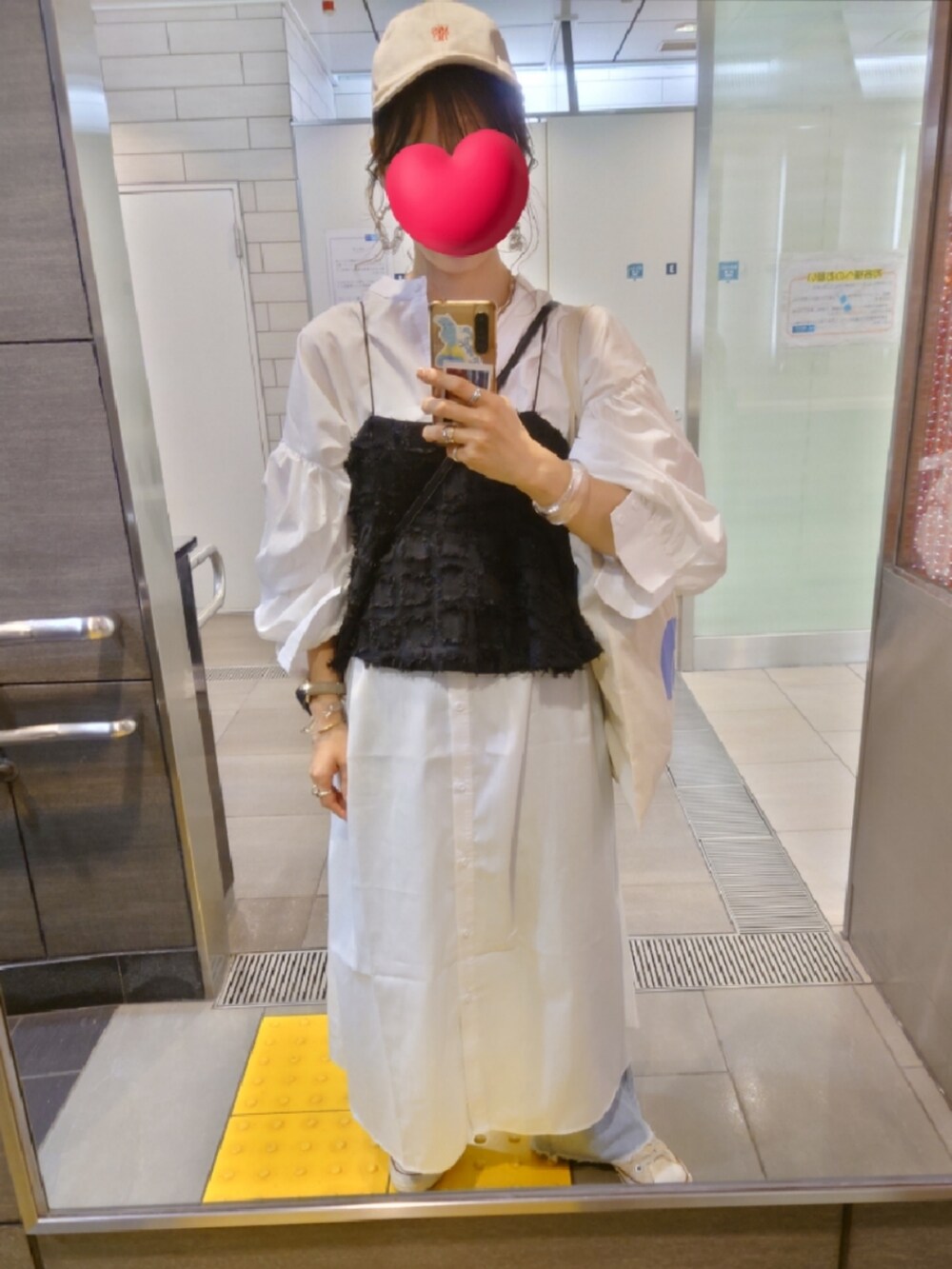 ブルー系のデニムパンツ、ホワイト系のワンピース、ブラック系のキャミソールを着用したレディースの春コーディネートの2枚目の写真