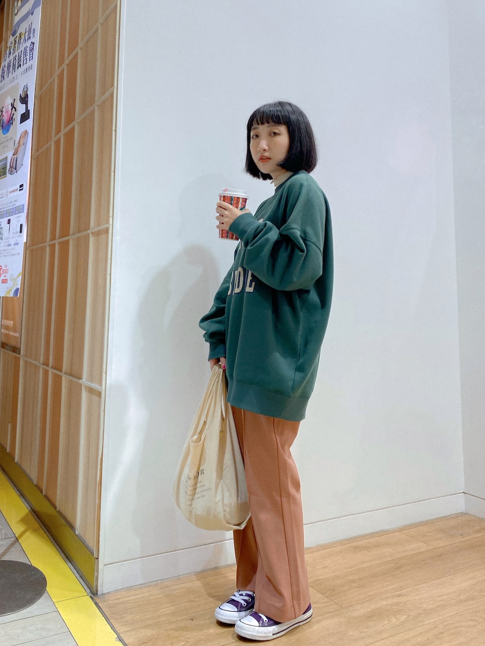グリーン系のスウェット、ピンク系のその他パンツ、ホワイト系のトートバッグを着用したレディースの春コーディネートの2枚目の写真