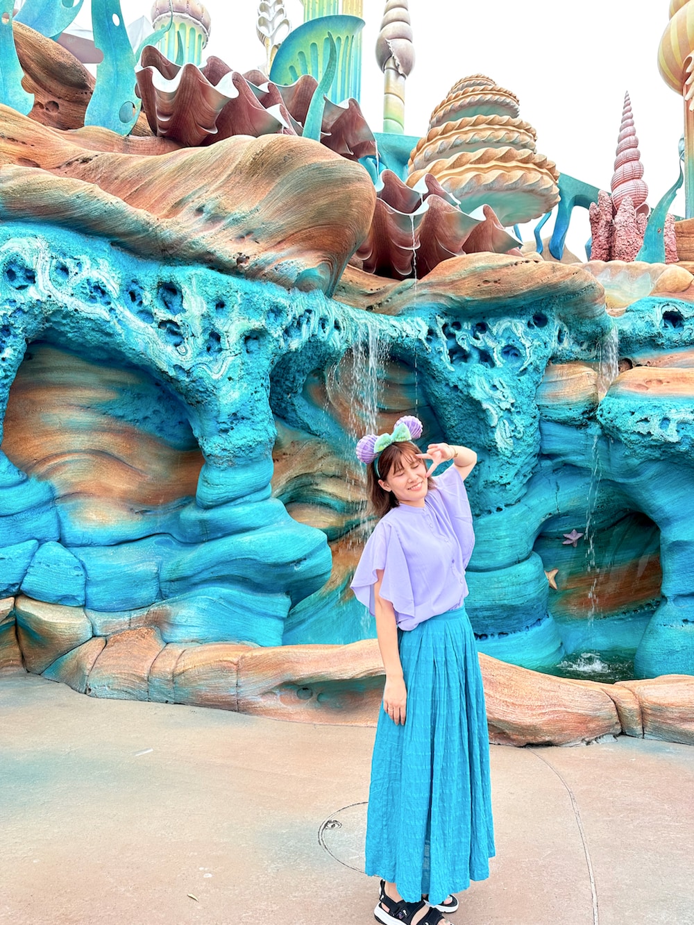 パープル系のシャツ/ブラウス、ブルー系のスカート、ブラック系のサンダルを着用したレディースの夏コーディネートの2枚目の写真