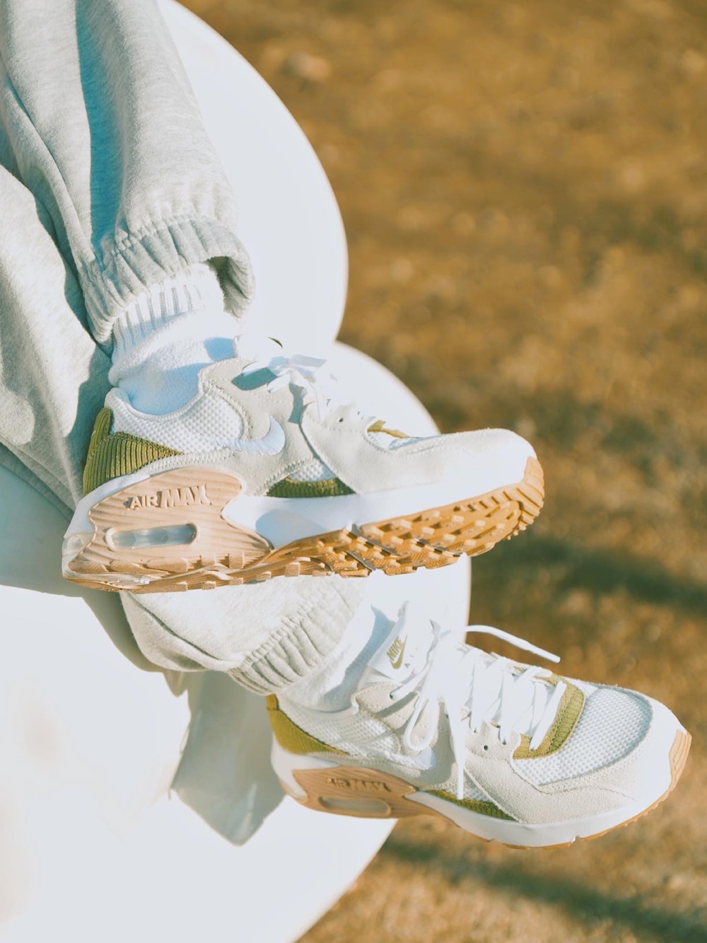 グリーン系のダウンベスト、ホワイト系のスウェット、グレー系のスウェットパンツを着用したレディースの冬コーディネートの3枚目の写真