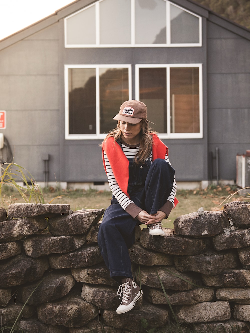 ブラウン系のTシャツ/カットソー、レッド系のニット/セーター、ブルー系のサロペット/オーバーオールを着用したレディースの冬コーディネートの5枚目の写真