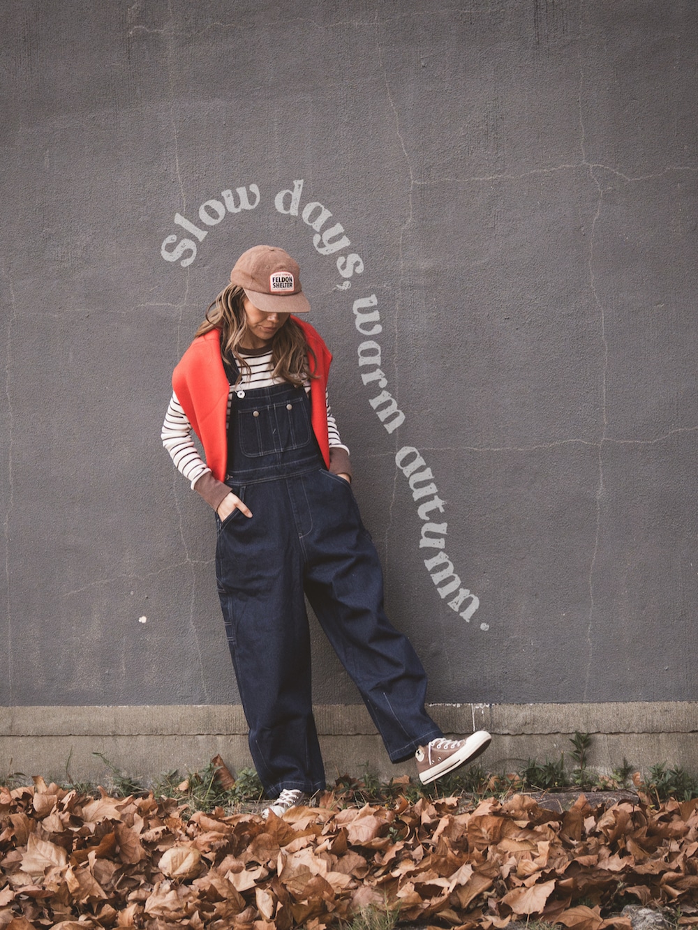 ブラウン系のTシャツ/カットソー、レッド系のニット/セーター、ブルー系のサロペット/オーバーオールを着用したレディースの冬コーディネートの3枚目の写真